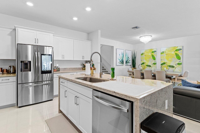 kitchen featuring stainless steel appliances, a sink, visible vents, and white cabinets