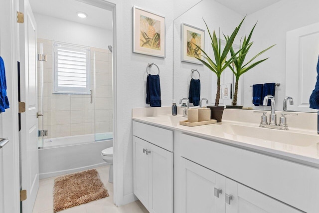 full bath featuring double vanity, shower / bathing tub combination, toilet, a sink, and tile patterned floors