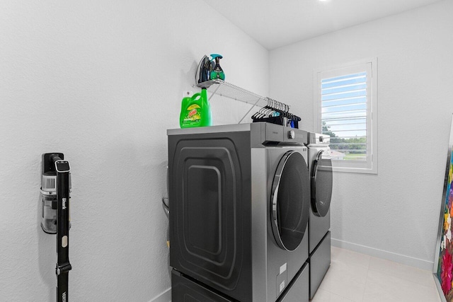 laundry room featuring light tile patterned floors, laundry area, independent washer and dryer, and baseboards