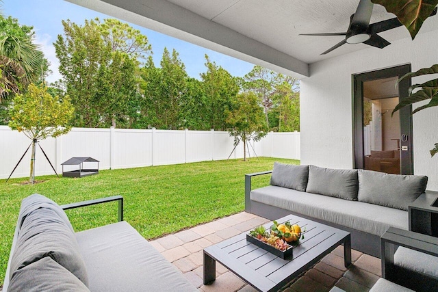 view of patio featuring ceiling fan, an outdoor living space, and a fenced backyard