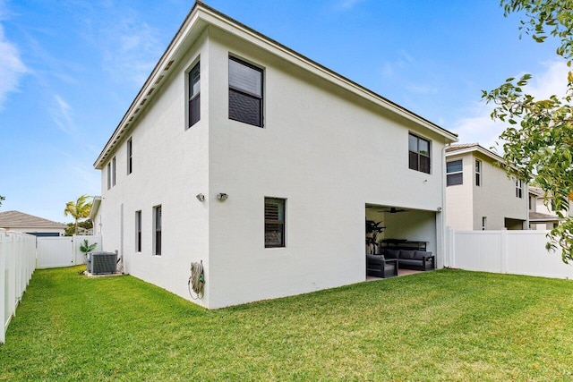 back of property with a fenced backyard, a lawn, and stucco siding