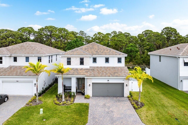 view of front facade featuring decorative driveway, a tiled roof, and a front lawn