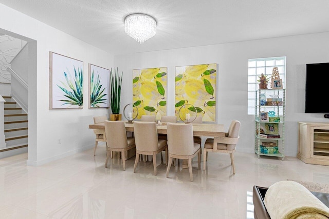 dining area with light tile patterned floors, a textured ceiling, a chandelier, baseboards, and stairs