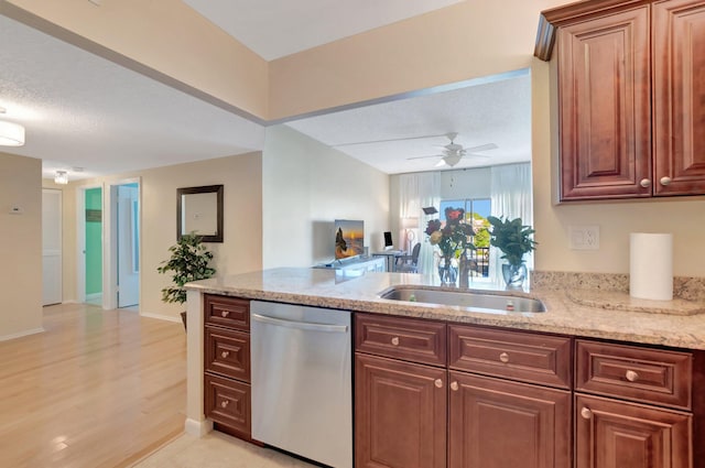 kitchen featuring ceiling fan, open floor plan, light stone counters, stainless steel dishwasher, and a sink