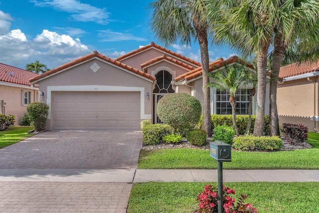 mediterranean / spanish-style home featuring a tiled roof, decorative driveway, an attached garage, and stucco siding