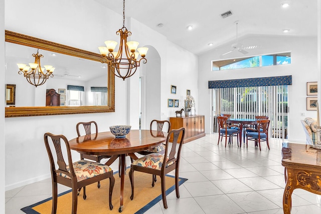 dining space featuring light tile patterned floors, visible vents, high vaulted ceiling, and ceiling fan with notable chandelier