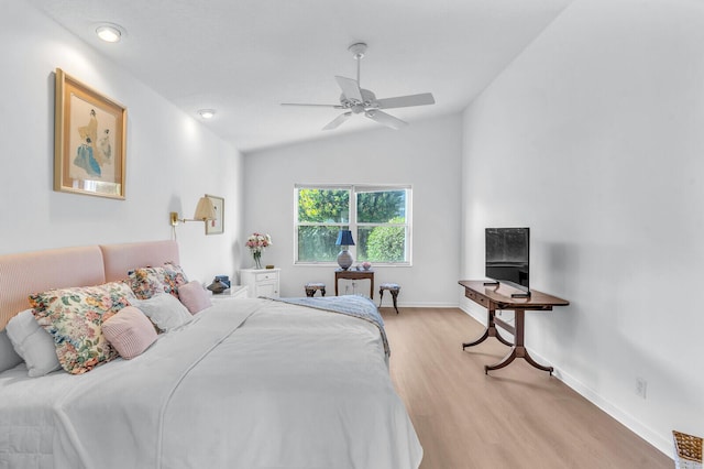 bedroom with a ceiling fan, lofted ceiling, baseboards, and light wood finished floors