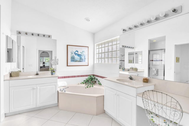 bathroom featuring a bath, vaulted ceiling, a sink, and tile patterned floors