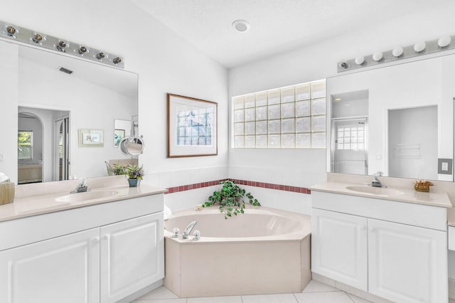 bathroom featuring a garden tub, plenty of natural light, and a sink