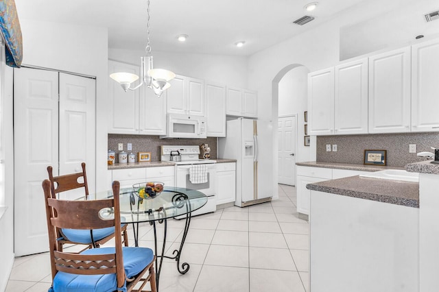 kitchen featuring light tile patterned floors, arched walkways, white appliances, visible vents, and white cabinets