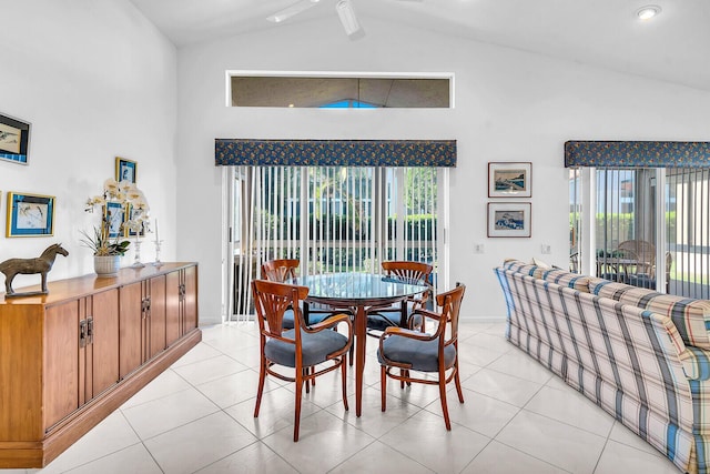 dining room with light tile patterned floors, high vaulted ceiling, and baseboards