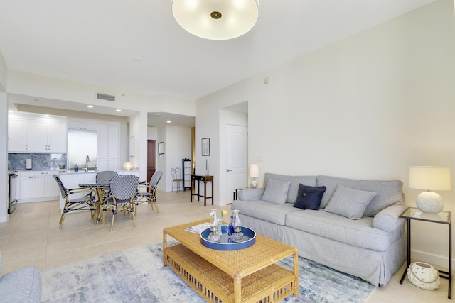 living room with light tile patterned flooring, visible vents, recessed lighting, and baseboards