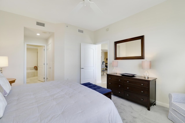 bedroom with ensuite bath, light colored carpet, visible vents, and baseboards