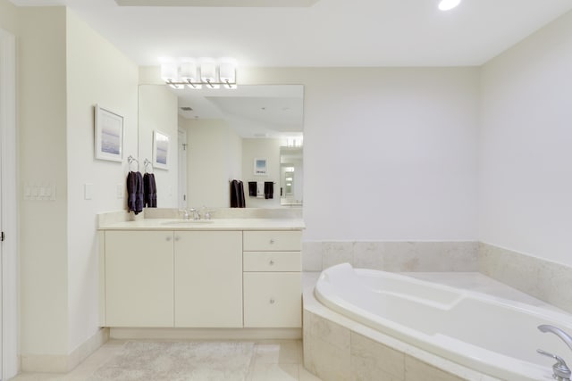 full bath featuring a bath, tile patterned floors, vanity, and baseboards