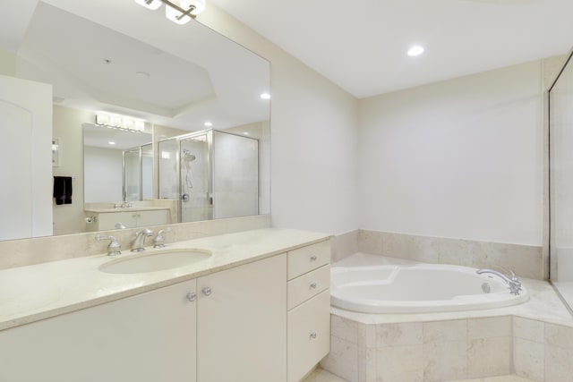 bathroom featuring vanity, a shower stall, a bath, and recessed lighting