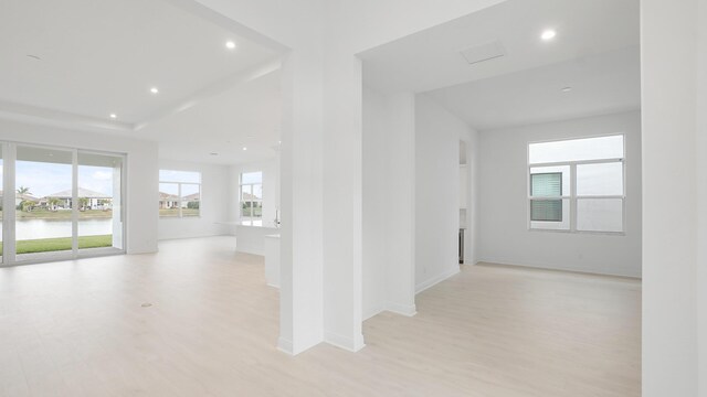 unfurnished room featuring light carpet, visible vents, baseboards, a raised ceiling, and recessed lighting