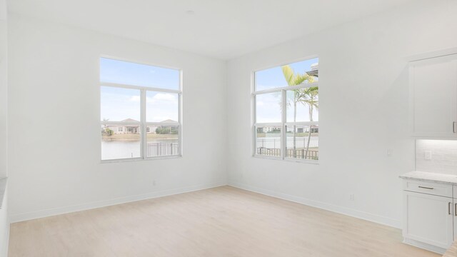 full bathroom with a water view, a spacious closet, a marble finish shower, and vanity