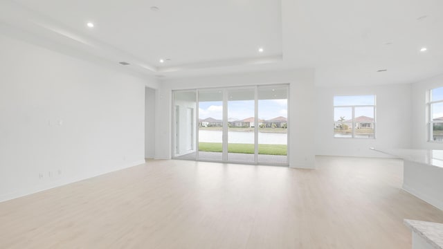 unfurnished living room featuring recessed lighting, plenty of natural light, and light wood-style flooring