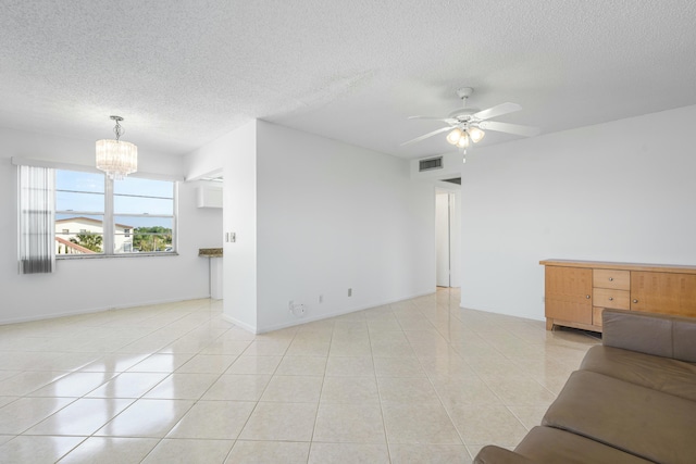 unfurnished living room with light tile patterned floors, baseboards, visible vents, a textured ceiling, and ceiling fan with notable chandelier