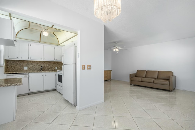 kitchen featuring white appliances, white cabinets, light tile patterned floors, and backsplash