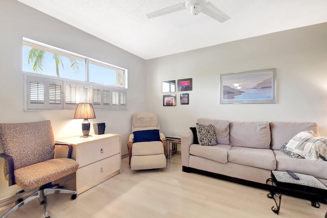 living room with light wood-type flooring, a textured ceiling, and a ceiling fan