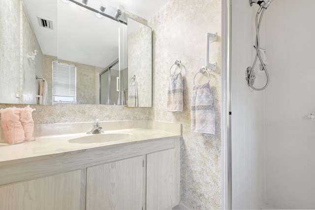 bathroom featuring a stall shower, vanity, and visible vents