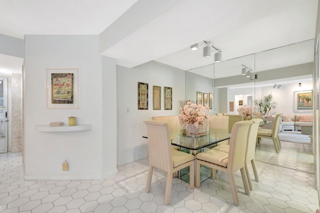 dining space featuring light tile patterned flooring and baseboards