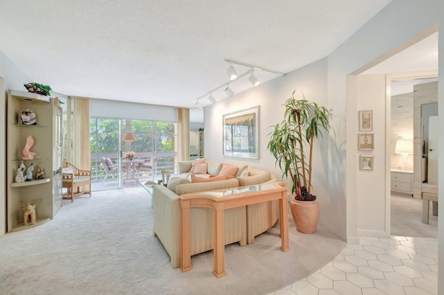 living area with light carpet, rail lighting, a wall of windows, a textured ceiling, and light tile patterned flooring