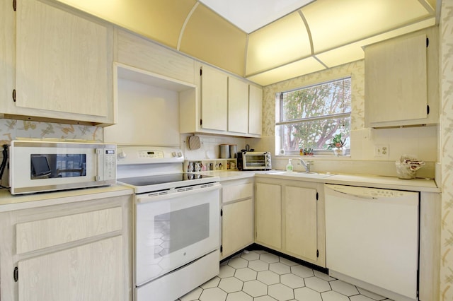 kitchen with white appliances, light countertops, a sink, and a toaster