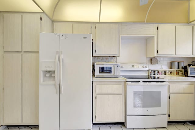 kitchen with white appliances, light countertops, backsplash, and light tile patterned floors