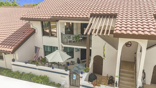 exterior space with a tile roof and stucco siding