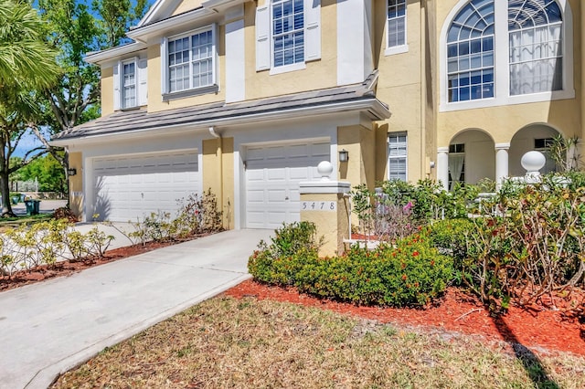 view of property featuring an attached garage and stucco siding