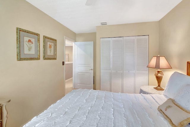 bedroom with ceiling fan, visible vents, and a closet