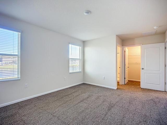 spare room with baseboards and carpet