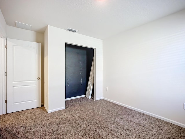 unfurnished bedroom featuring visible vents, baseboards, and carpet