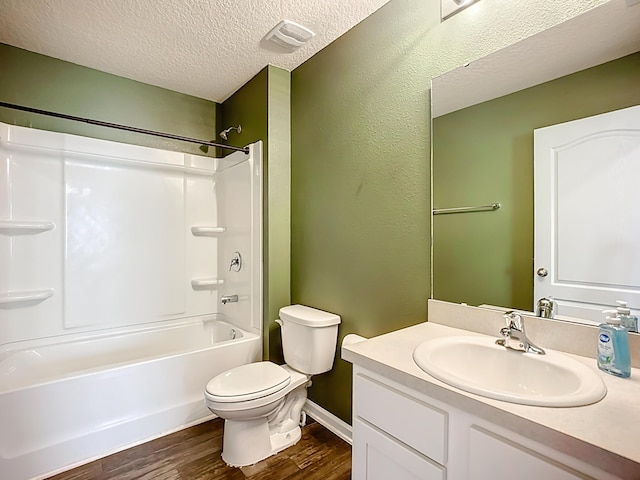 bathroom with visible vents, toilet, a textured ceiling, wood finished floors, and vanity