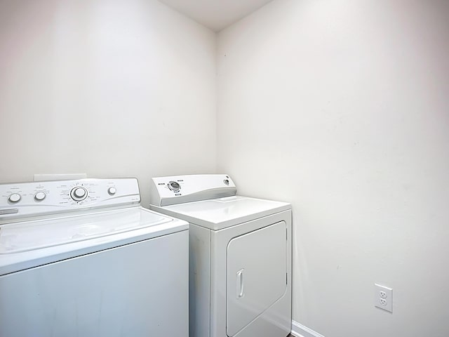 laundry room with laundry area, baseboards, and separate washer and dryer