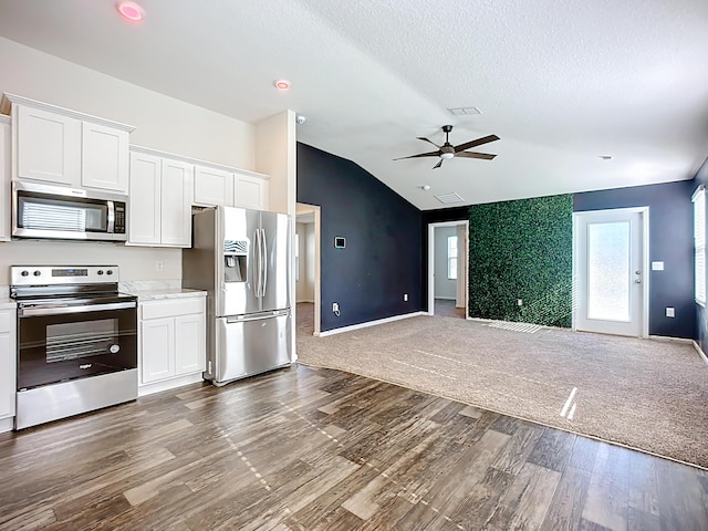 kitchen with open floor plan, lofted ceiling, white cabinets, stainless steel appliances, and dark wood-style flooring