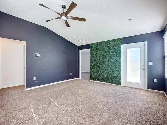 empty room with a ceiling fan, visible vents, vaulted ceiling, a textured ceiling, and carpet flooring