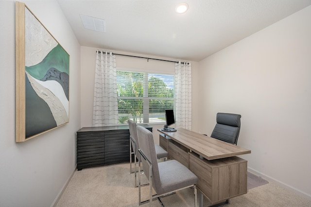 carpeted office space featuring baseboards and visible vents