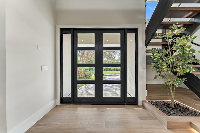 interior space featuring french doors, wood finished floors, and baseboards