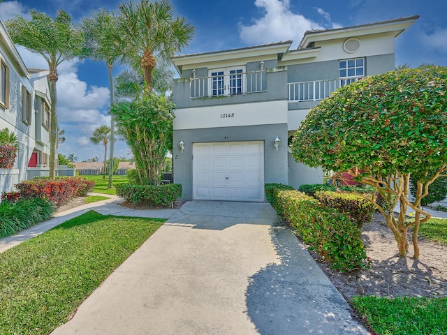 view of front facade with stucco siding, an attached garage, and driveway