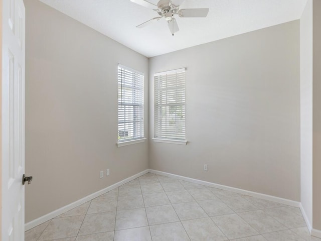 spare room with a ceiling fan, baseboards, and light tile patterned floors