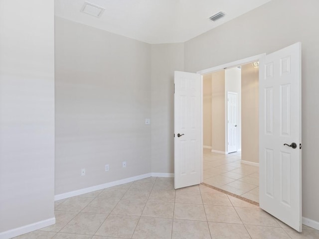 spare room featuring visible vents, baseboards, and light tile patterned flooring