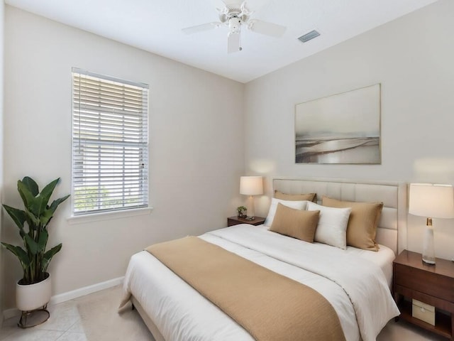 tiled bedroom featuring visible vents, a ceiling fan, and baseboards