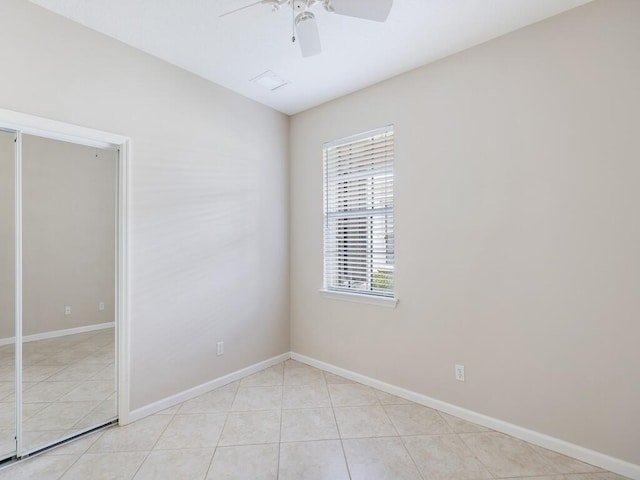 unfurnished room featuring a ceiling fan, light tile patterned flooring, and baseboards