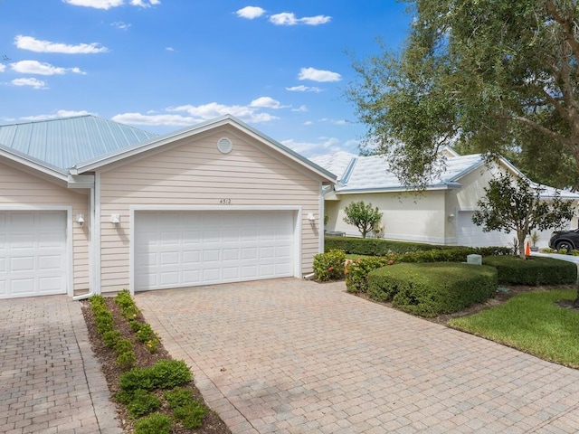 ranch-style home with decorative driveway and an attached garage