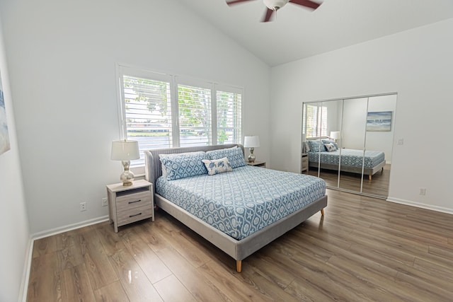 bedroom featuring ceiling fan, high vaulted ceiling, wood finished floors, and baseboards