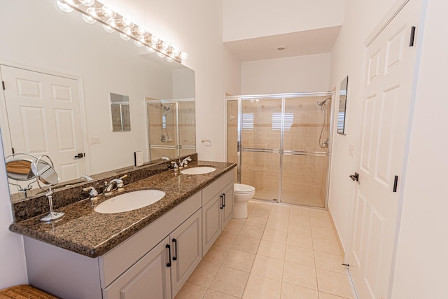 full bath featuring double vanity, a stall shower, a sink, and tile patterned floors