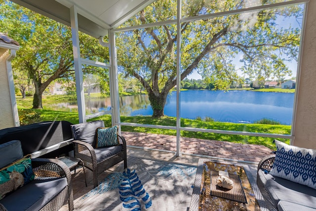 sunroom featuring a water view and lofted ceiling